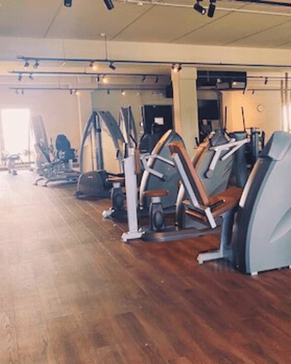 Trainingsfläche im Studio Germersheim: helle Halle mit Holzboden und grauen Kraftgeräten unter Deckenstrahlern