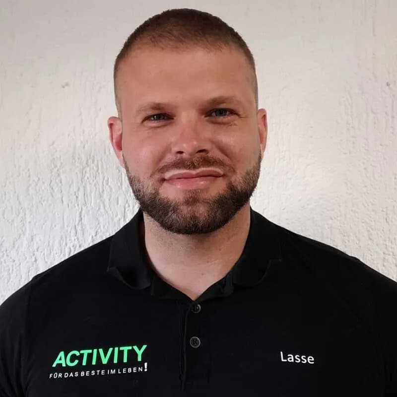 Lasse, Trainer in Bürstadt, im schwarzen ACTIVITY-Shirt vor heller Wand