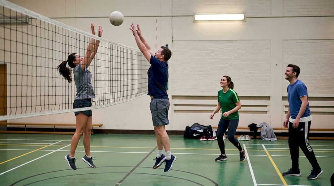 Eine Mannschaft trifft sich in der Sporthalle zu einem entspannten Volleyballmatch.