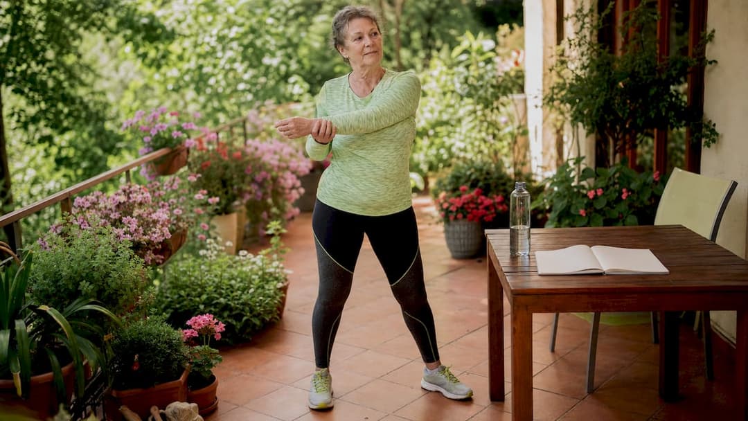 Ältere Dame hält sich mit Bewegungsübungen in den eigenen vier Wänden fit.